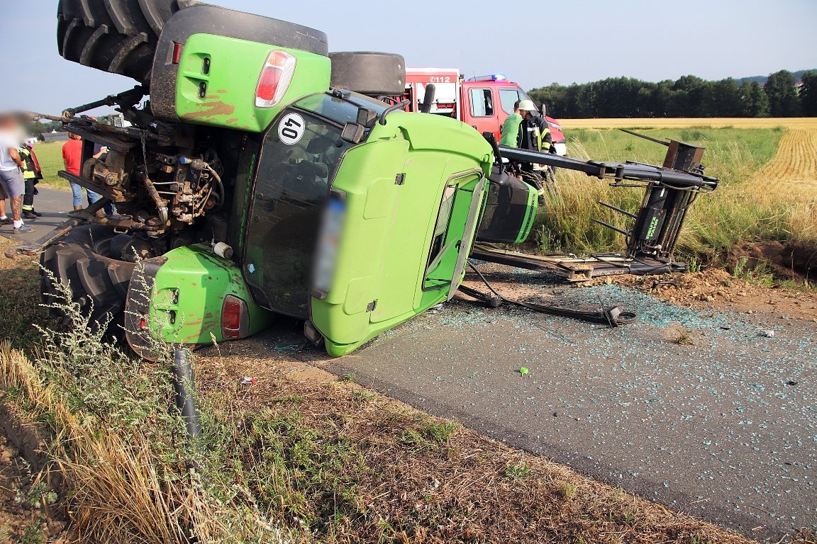Traktor spießt sich und kippt auf Straße