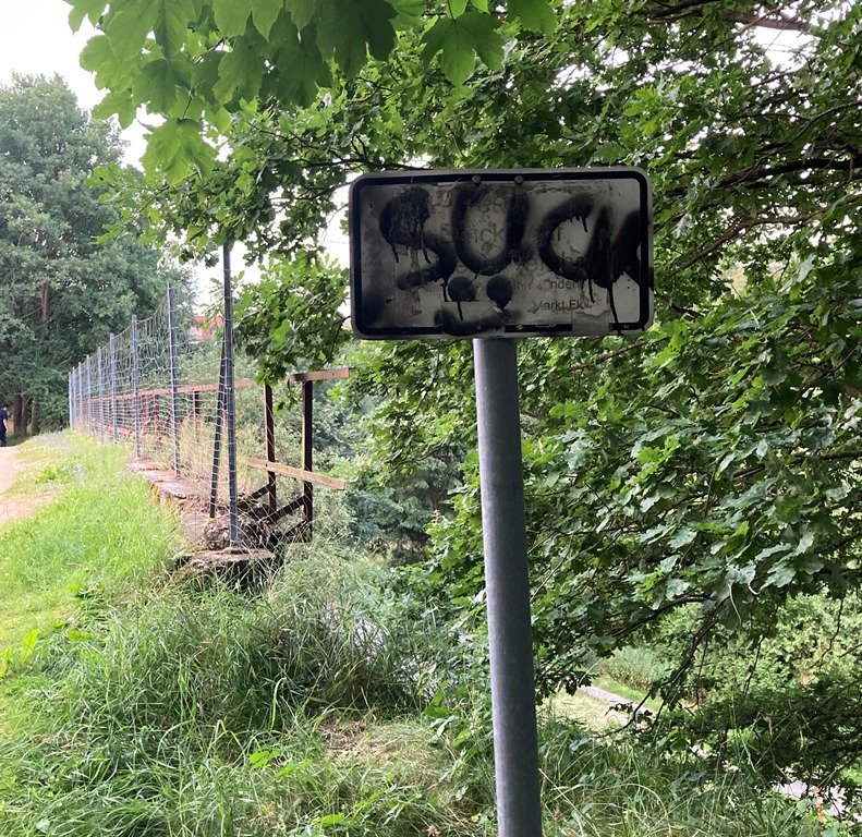 Eisenbahnbrücke und Schild beschmiert