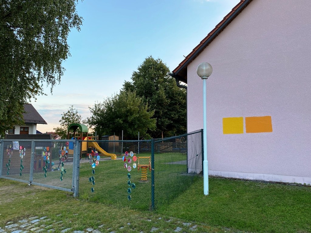Photovoltaikanlage auf Kulturscheune und leuchtendes Orange für den Kindergarten