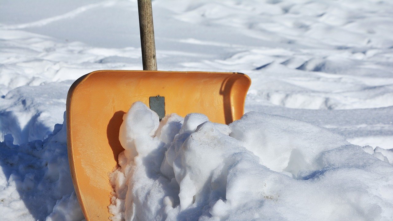 Mann in grüner Jogginghose klaut Schneeschaufel