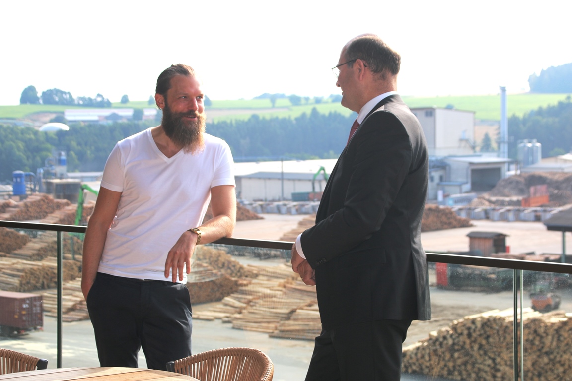 Stefan Ziegler präsentiert Finanzminister Füracker die Vision von der Stadt aus Holz