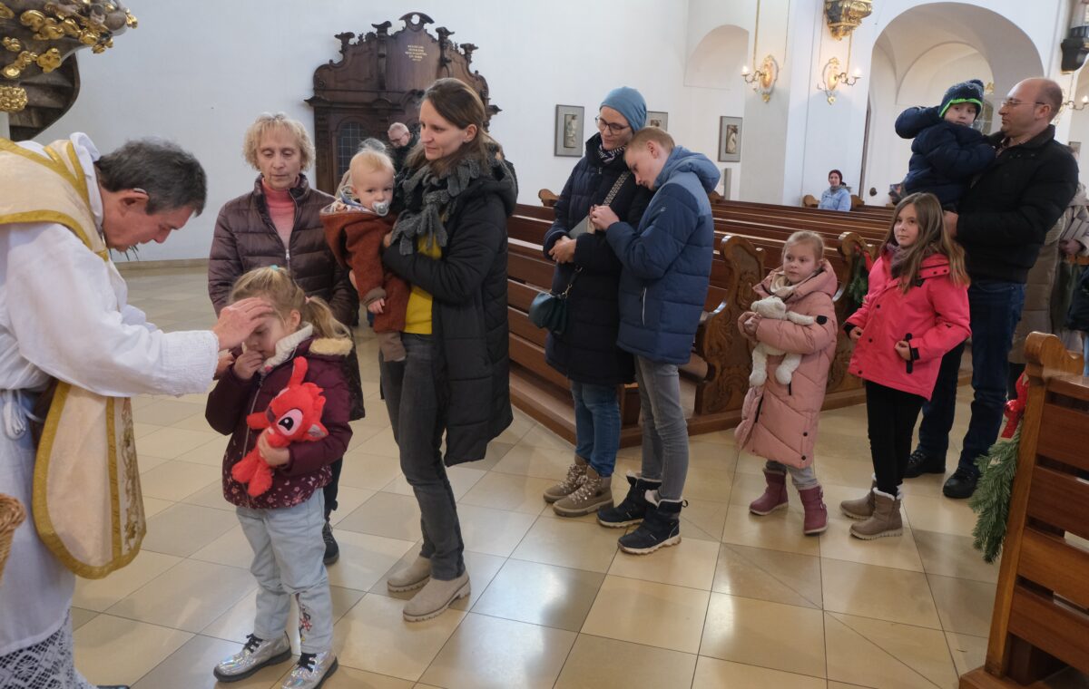 Pfarrer Früchtl segnet Kinder in Floß
